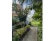 Serene landscaped pathway leading to a lush green lawn, surrounded by vibrant tropical foliage at 4741 Chevy Pl # 149C2L, Orlando, FL 32811