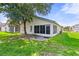 Landscaped backyard featuring a screened-in patio, perfect for outdoor enjoyment at 5703 Arnold Zlotoff Dr, Orlando, FL 32821