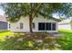 Backyard featuring a tree for shade, screened-in porch, and partial grass coverage at 5703 Arnold Zlotoff Dr, Orlando, FL 32821