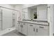 Bright bathroom with a double sink vanity with granite counters and a walk in shower with built-in shelves at 5808 Arboretum St, St Cloud, FL 34771