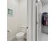 Powder room featuring a modern toilet and stylish gray floors located near a walk-in closet at 5808 Arboretum St, St Cloud, FL 34771