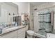 Bathroom featuring a granite vanity, toilet, and a shower with marble-style tile and a shower curtain at 5808 Arboretum St, St Cloud, FL 34771