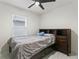 Cozy bedroom with gray bedding, a ceiling fan, and a window with blinds at 5808 Arboretum St, St Cloud, FL 34771