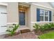 Inviting front entrance featuring a stylish blue front door, brick pathway, and colorful landscaping at 5808 Arboretum St, St Cloud, FL 34771