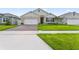 Beautiful home exterior with lush green lawn, a brick driveway, and a well-maintained facade at 5808 Arboretum St, St Cloud, FL 34771