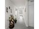 Long hallway with neutral walls, tile flooring, and decorative accents leading to other rooms at 5808 Arboretum St, St Cloud, FL 34771