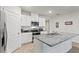 Close up of kitchen with white cabinets, stainless appliances, granite counters, and center island with sink at 5808 Arboretum St, St Cloud, FL 34771