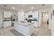 Bright kitchen with white cabinetry, stainless appliances, granite counters, and a large center island with a sink at 5808 Arboretum St, St Cloud, FL 34771