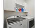 Well-equipped laundry room with modern washer and dryer, and ample storage cabinets at 5808 Arboretum St, St Cloud, FL 34771
