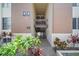 Close up of condo building with mature green landscaping surrounding the entryway at 614 Orange Dr # 196, Altamonte Springs, FL 32701