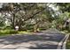 Gated community entrance with mature trees and landscaping along the drive at 6214 Stevenson Dr # 208, Orlando, FL 32835