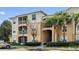 Multi-level condo building with beige exterior, palm trees, screened patios and convenient parking at 6214 Stevenson Dr # 208, Orlando, FL 32835