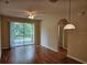 Open-concept living space with sliding glass doors to a balcony, ceiling fan, and wood-look floors at 6214 Stevenson Dr # 208, Orlando, FL 32835