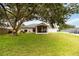 Spacious backyard featuring a large tree, a screened patio, and lush green lawn, perfect for outdoor enjoyment at 630 Park Valley Cir, Minneola, FL 34715