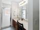 Bright bathroom featuring a marble-top vanity, a large mirror, and a glass-enclosed shower at 630 Park Valley Cir, Minneola, FL 34715
