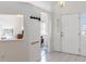 Bright entryway with white tile flooring, coat hooks, and a glimpse into other rooms of the home at 630 Park Valley Cir, Minneola, FL 34715