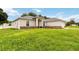 A view of the side and front of this single-story home, showing a brick foundation and lush lawn at 630 Park Valley Cir, Minneola, FL 34715