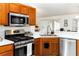 Well-equipped kitchen featuring stainless steel appliances, wooden cabinets, and white countertops at 630 Park Valley Cir, Minneola, FL 34715