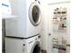 Modern laundry room featuring stacked washer and dryer plus convenient shelving at 630 Park Valley Cir, Minneola, FL 34715