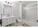 Bright bathroom featuring white vanity with storage, and shower-tub combo with glass doors at 6388 Castelven Dr # 102, Orlando, FL 32835