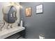 Stylish powder room featuring a unique round mirror and elegant fixtures at 6388 Castelven Dr # 102, Orlando, FL 32835
