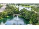 Aerial view of the community lake featuring a water fountain and mature trees at 6388 Castelven Dr # 102, Orlando, FL 32835