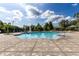 Community pool featuring a paved deck, clear water, fountain, and lush tropical landscaping at 6388 Castelven Dr # 102, Orlando, FL 32835