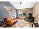 Comfortable home office space featuring hardwood floors, a leather sofa, and a modern desk setup at 6388 Castelven Dr # 102, Orlando, FL 32835