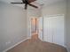 This bedroom showcases an open closet, ceiling fan, and neutral carpet for versatile use at 7462 Bentonshire Ave, Windermere, FL 34786
