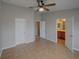 Neutral bedroom featuring tile floors, ceiling fan, and convenient access to both a bathroom and a closet at 7462 Bentonshire Ave, Windermere, FL 34786