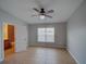 Bedroom with neutral walls, tile floors, a ceiling fan, and bright window light at 7462 Bentonshire Ave, Windermere, FL 34786