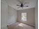 Neutral bedroom with a large window, ceiling fan, and plush carpeting providing a serene atmosphere at 7462 Bentonshire Ave, Windermere, FL 34786
