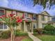 Beautiful two-story townhouse showcasing its inviting entrance, red shutters, and lush landscaping at 7462 Bentonshire Ave, Windermere, FL 34786