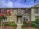 Inviting townhouse with a covered entryway framed by colorful landscaping and a freshly painted facade at 7462 Bentonshire Ave, Windermere, FL 34786