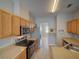 Well-lit kitchen with stainless steel appliances and wooden cabinets with long countertops at 7462 Bentonshire Ave, Windermere, FL 34786