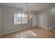 View of the living room, showcasing tile floors, chandelier lighting, and a bright window at 7462 Bentonshire Ave, Windermere, FL 34786