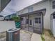 View of the screened patio with a white fence, tropical foliage, and outdoor A/C unit at 7462 Bentonshire Ave, Windermere, FL 34786