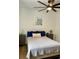 Neutral bedroom with ceiling fan, wood floors, accent wall decor, and two bedside tables at 8010 Tuscany Way # 3102, Davenport, FL 33896