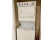 Stacked, white washing machine and dryer inside a laundry closet with open door at 8010 Tuscany Way # 3102, Davenport, FL 33896