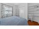 Bedroom featuring built-in shelves, closet, and blue bedding with beautiful hardwood floors at 815 E 11Th Ave, Mount Dora, FL 32757