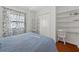 Bedroom featuring built-in shelves, closet, and blue bedding with beautiful hardwood floors at 815 E 11Th Ave, Mount Dora, FL 32757