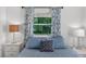 Bright bedroom featuring blue bedding, side tables, and natural light at 815 E 11Th Ave, Mount Dora, FL 32757