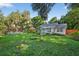 Charming single-story home with a bright blue front door, large manicured front lawn, and playset at 815 E 11Th Ave, Mount Dora, FL 32757