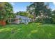 Charming single-story home with a bright blue front door, carport, and large manicured front lawn at 815 E 11Th Ave, Mount Dora, FL 32757