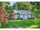 Charming single-story home with a bright blue front door, carport, and large front lawn at 815 E 11Th Ave, Mount Dora, FL 32757