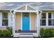 Close up of the porch with a blue door, decorative lattice, and well-maintained landscaping at 815 E 11Th Ave, Mount Dora, FL 32757