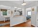 Hallway view showcasing hardwood floors, a pass-through to the kitchen, and access to other rooms at 815 E 11Th Ave, Mount Dora, FL 32757