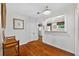 Hallway featuring wood floors, a decorative bench, and a view into the kitchen with white cabinets at 815 E 11Th Ave, Mount Dora, FL 32757