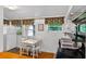 Kitchen area with white cabinets, a dining table, and stainless steel appliances offering modern convenience at 815 E 11Th Ave, Mount Dora, FL 32757
