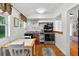 Compact kitchen area with stainless steel appliances, white cabinets, and a dining table for casual meals at 815 E 11Th Ave, Mount Dora, FL 32757